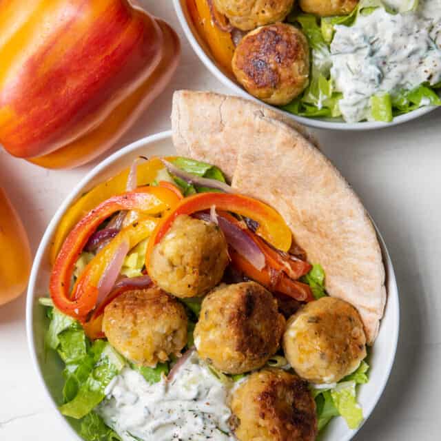 Two vegetarian gyro bowls with Aloha peppers on the side