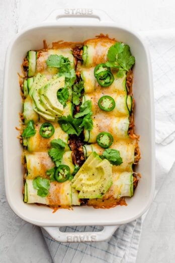 Final zucchini enchiladas garnished with cilantro, jalapenos and avocado